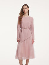 A lady wears a sweater and a pink tulle skirt.
